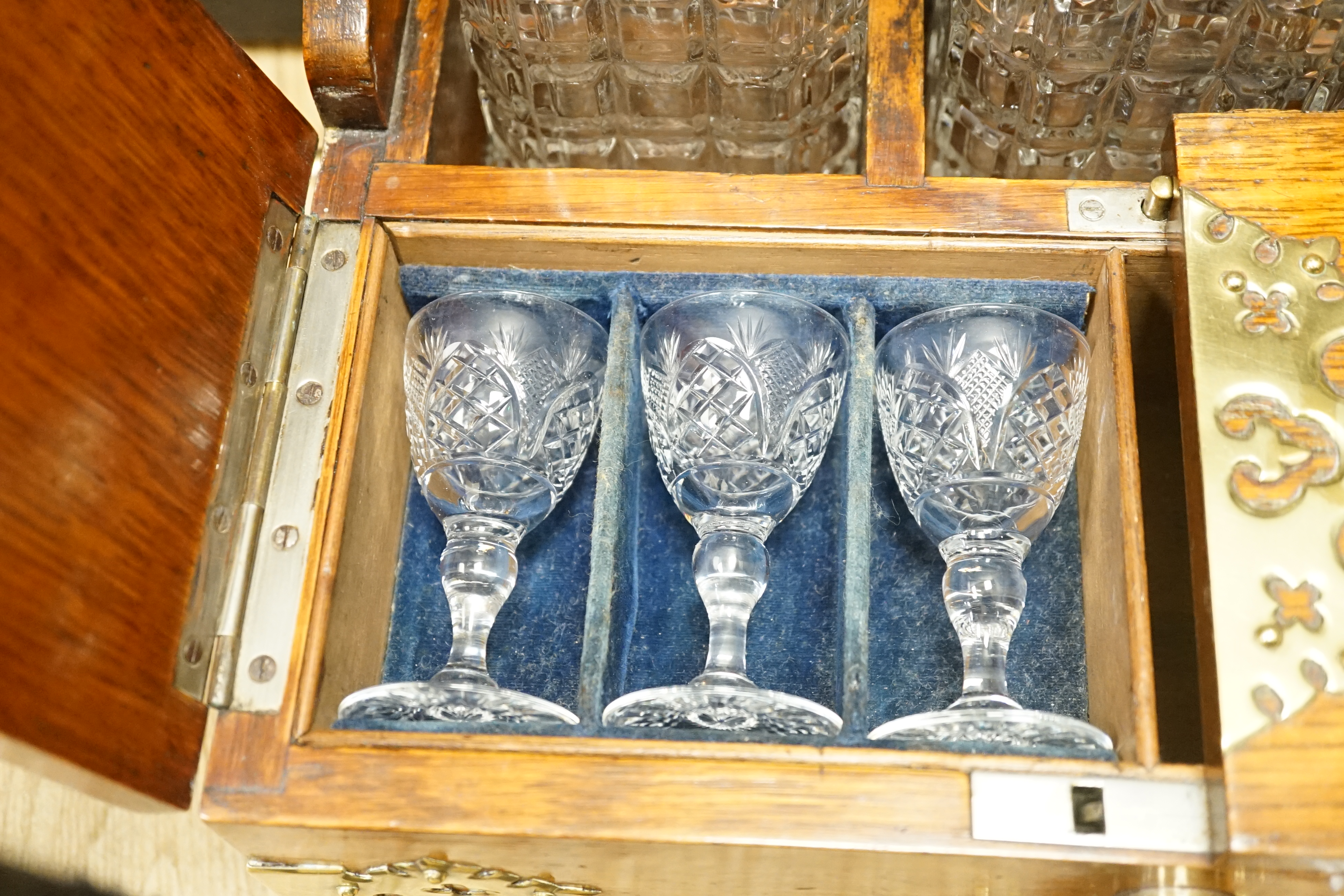 A Victorian oak and brass mounted three bottle tantalus, with base drawer and key, 36.5 cm wide